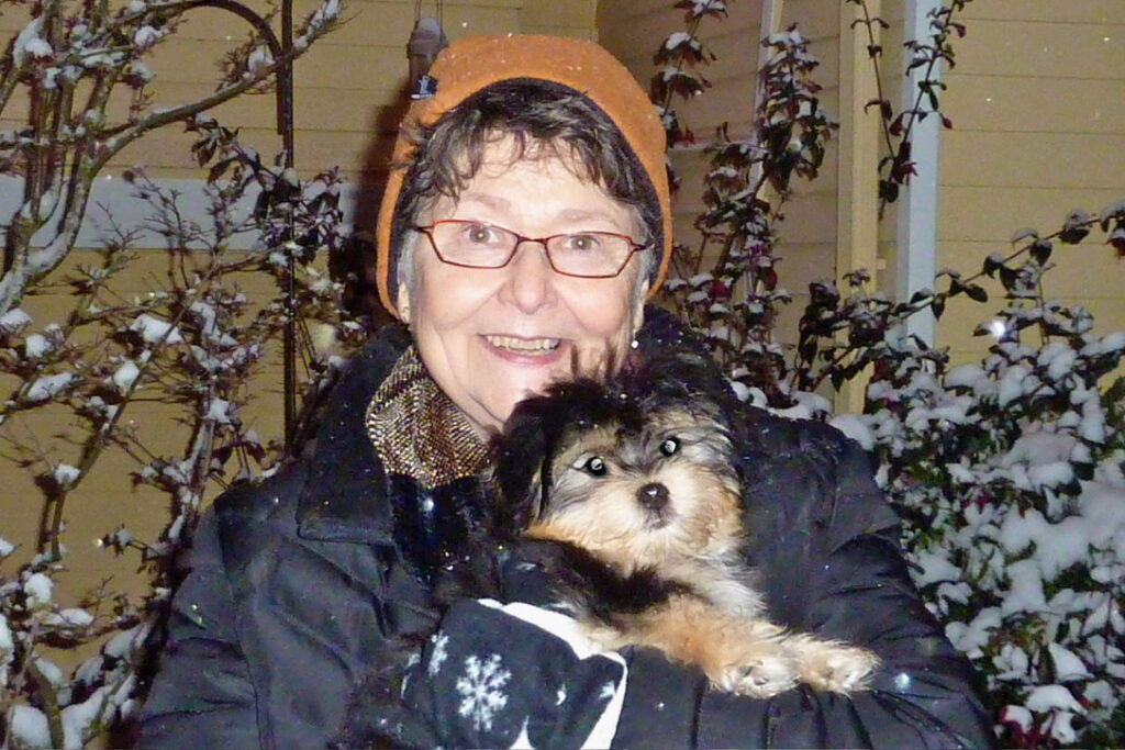 Happy smiling woman in the wintertime, with her dear Havanese in her arms